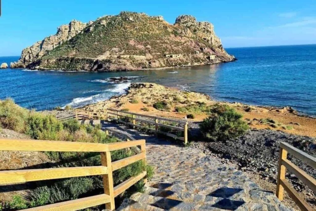 Imagen de una pasarela de Águilas donde se observa de fondo la Isla del Fraile para hablar sobre d?nde est? la Costa Cálida.